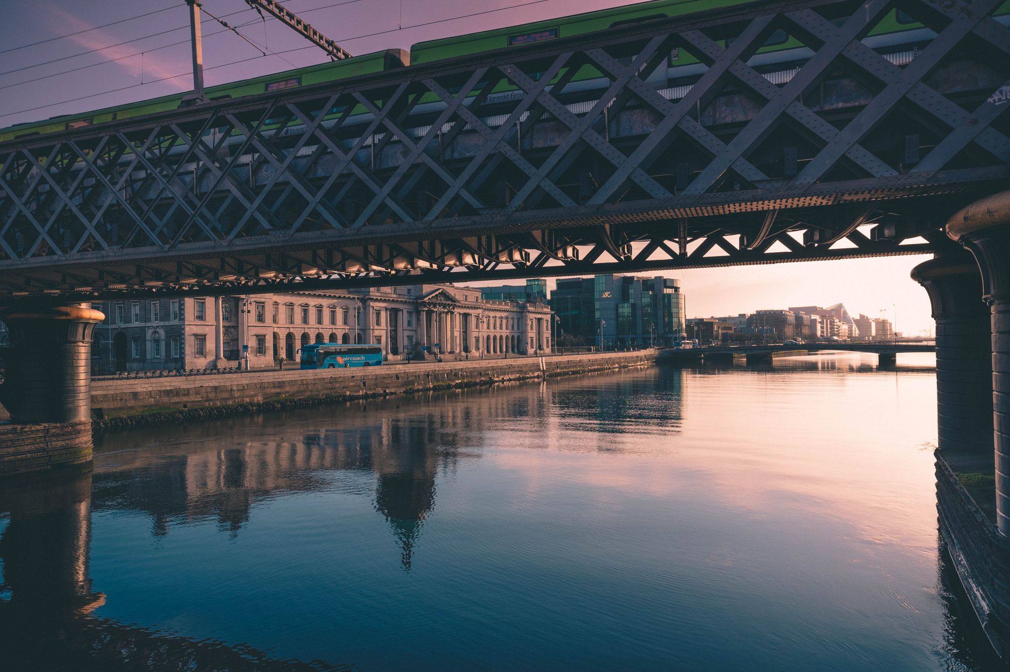 Puente y edificios de Dublín reflejados en el río Liffey al atardecer