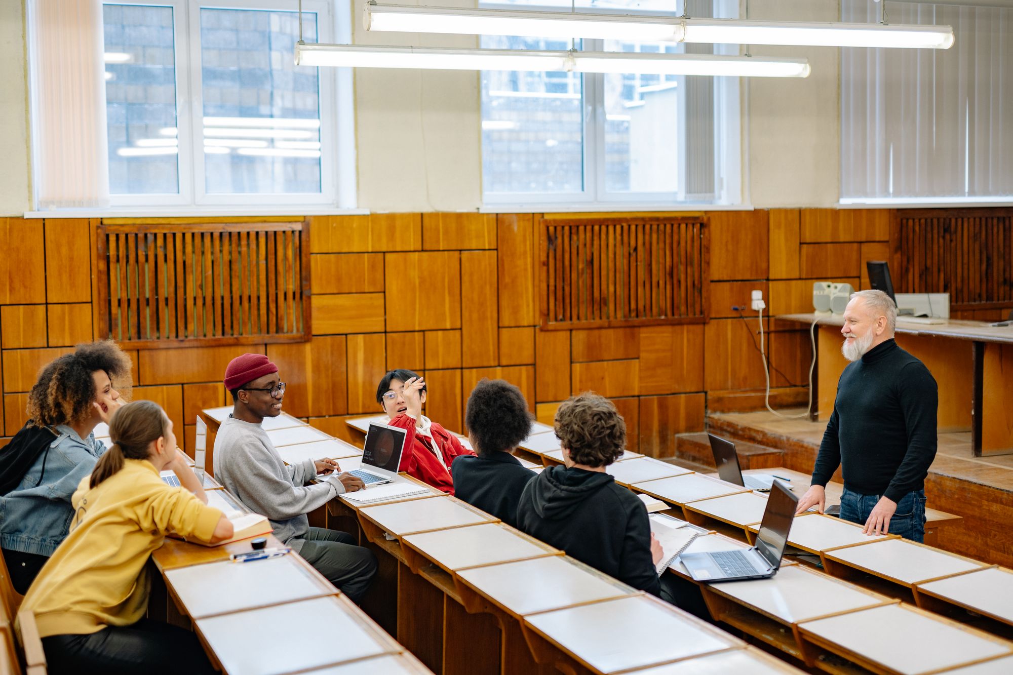 Estudiantes adultos participando en una clase con su profesor