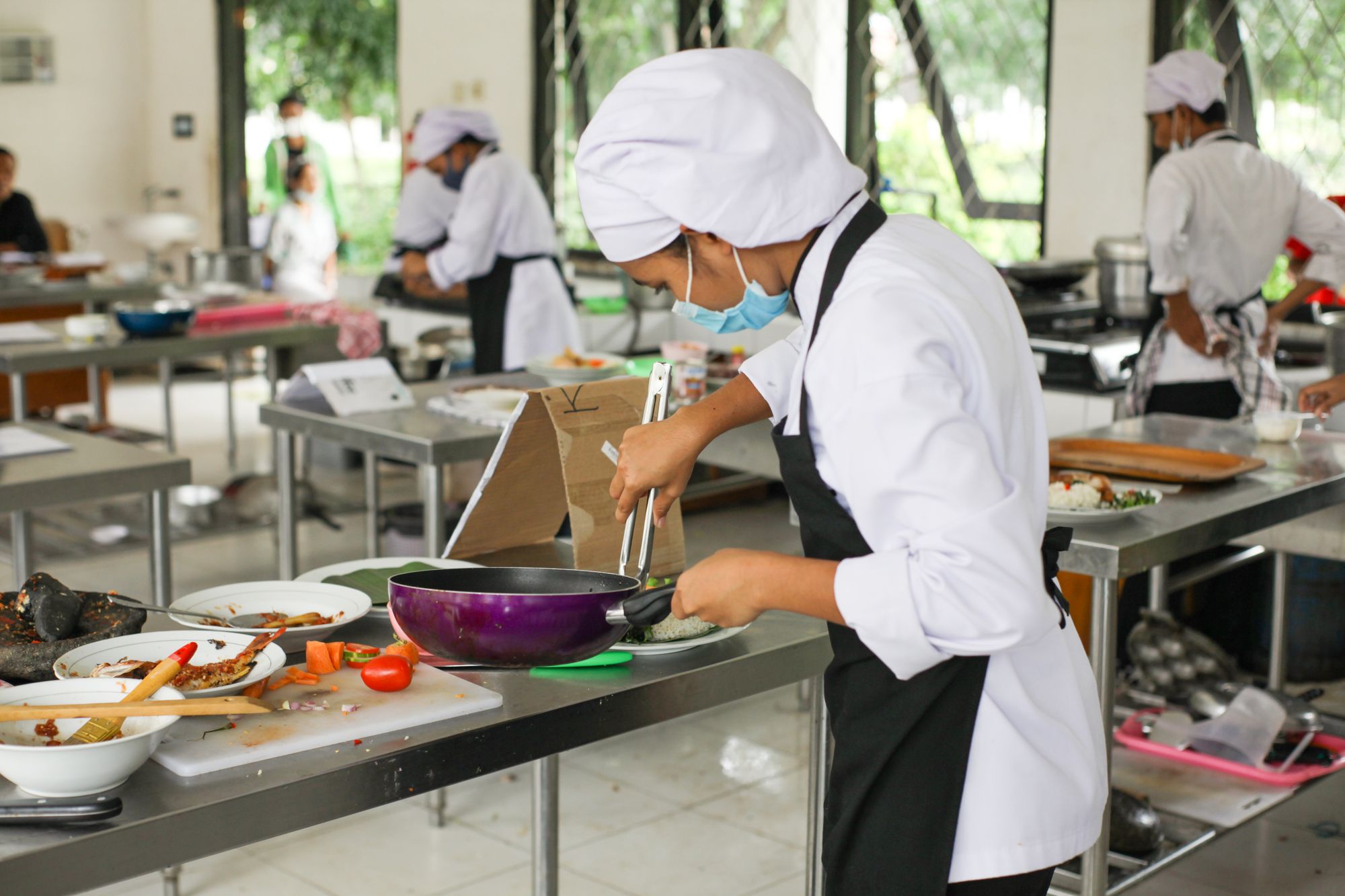 Estudiantes de cocina practicando en una cocina profesional